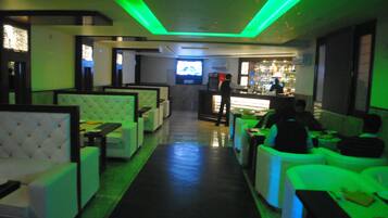 A dimly lit restaurant with booths and a bar area.