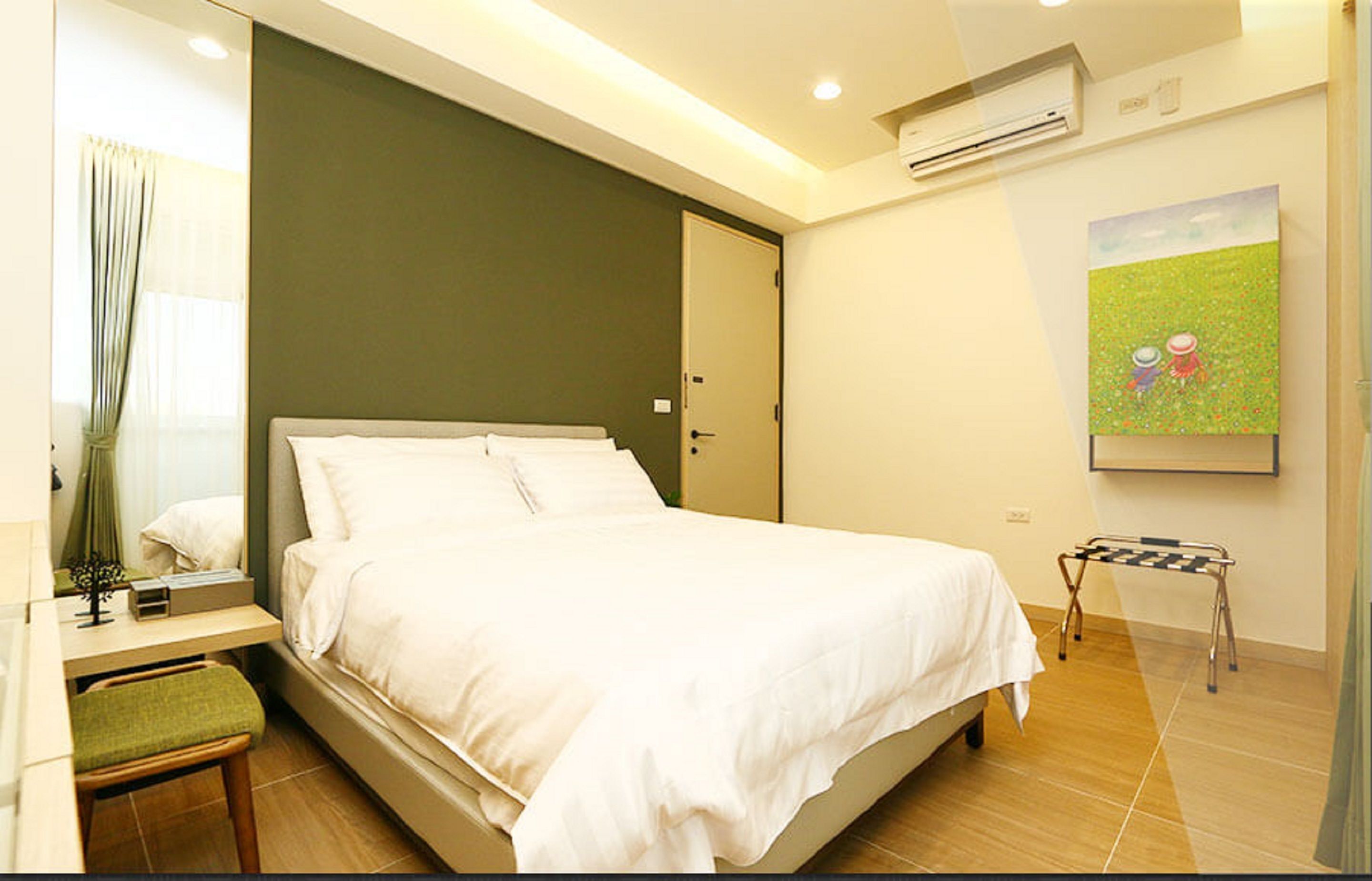 A modern bedroom with a bed, bedside table, and a small stool.