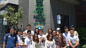 A group of people in front of a building with a sign that reads "Green Villa."