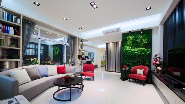 A modern living room with a sofa, red chairs, a coffee table, and a bookshelf.