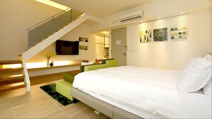 A modern bedroom with a large bed, a staircase, and a flat-screen TV.
