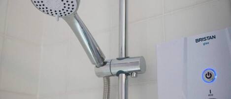Une douche équipée d’un pommeau de douche à main et d’un panneau de commande portant l’inscription « BRISTAN glee ».