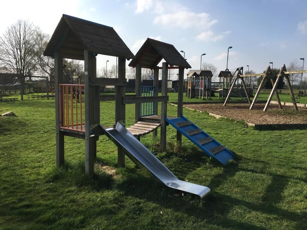 A playground with a slide and climbing structures.