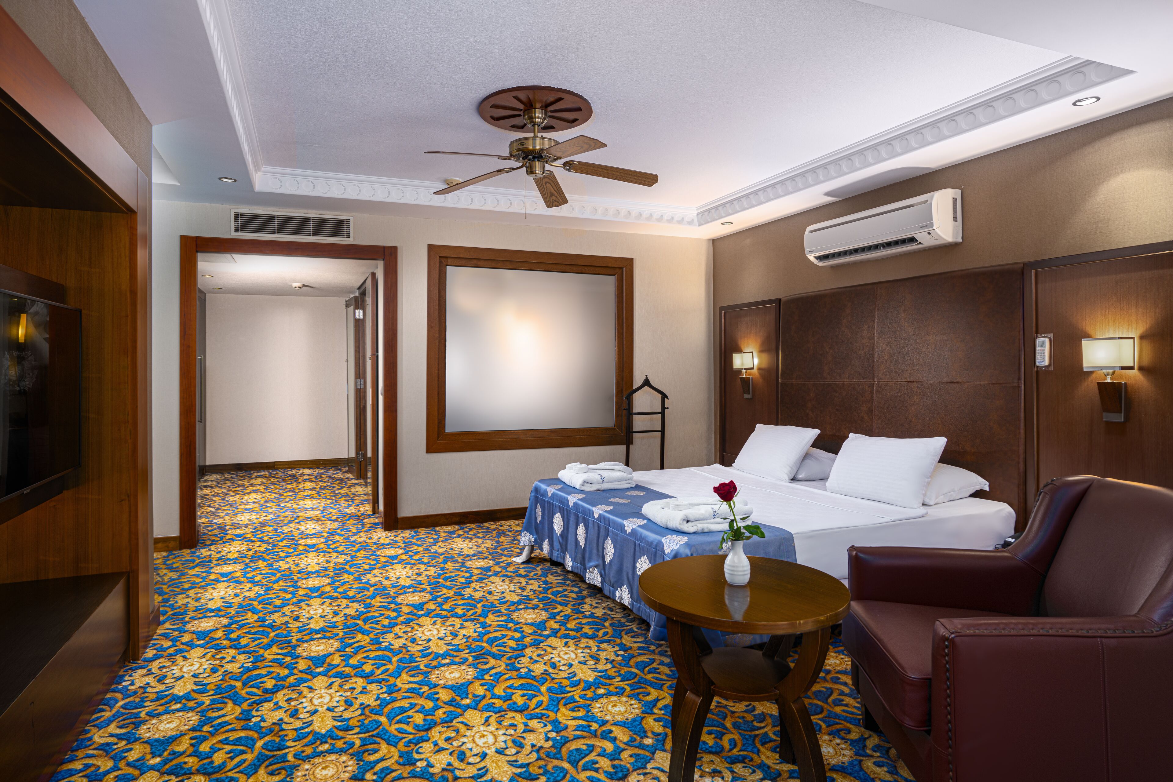 Una habitación de hotel con cama, una silla, una mesa y televisión.