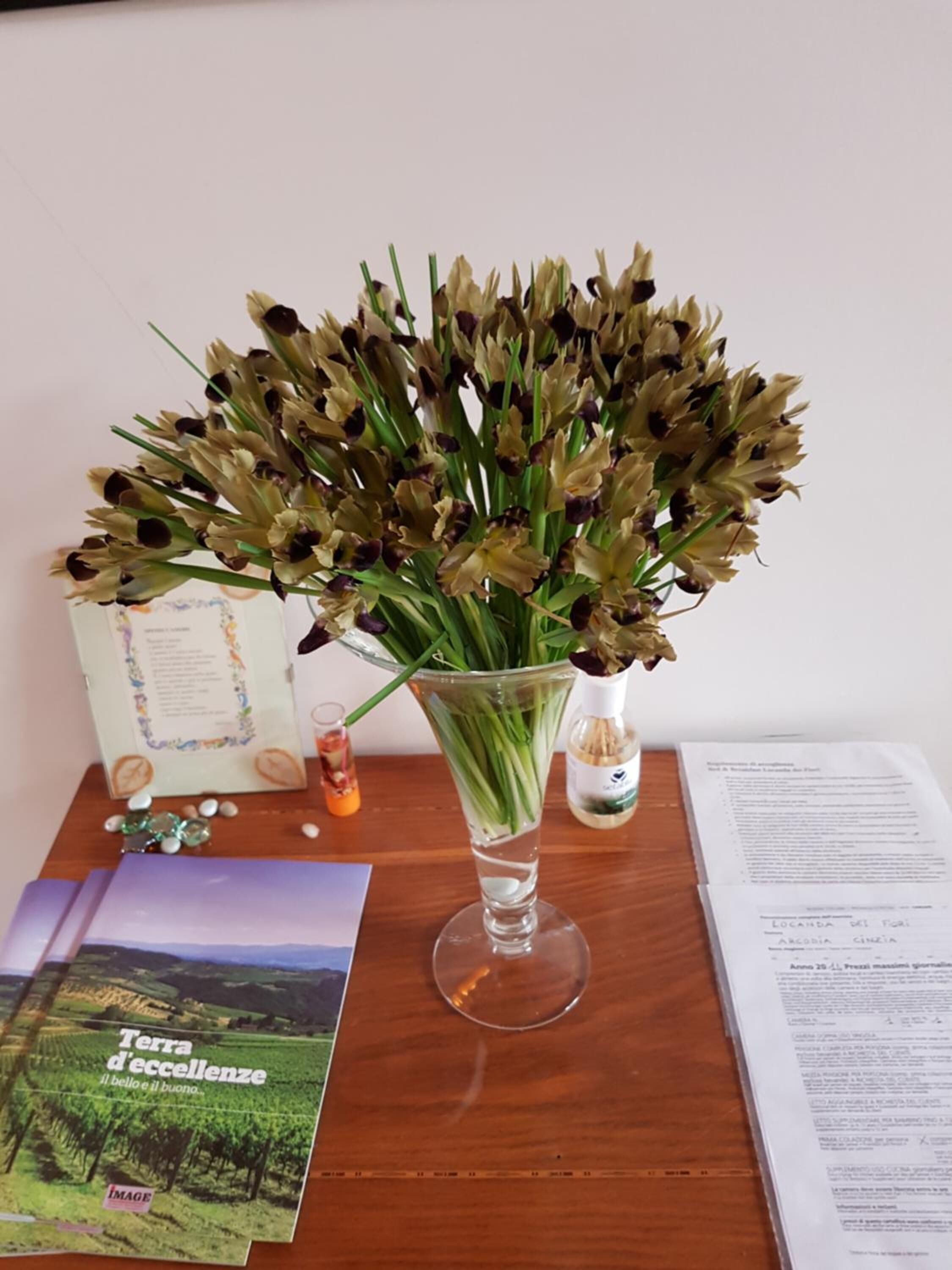 A clear glass vase with a bouquet of flowers on a wooden table.