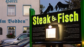 Un hotel llamado "M. Bodden" con un letrero que anuncia el restaurante "Steak & Fisch".