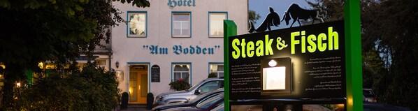 Un hotel llamado "M. Bodden" con un letrero que anuncia el restaurante "Steak & Fisch".