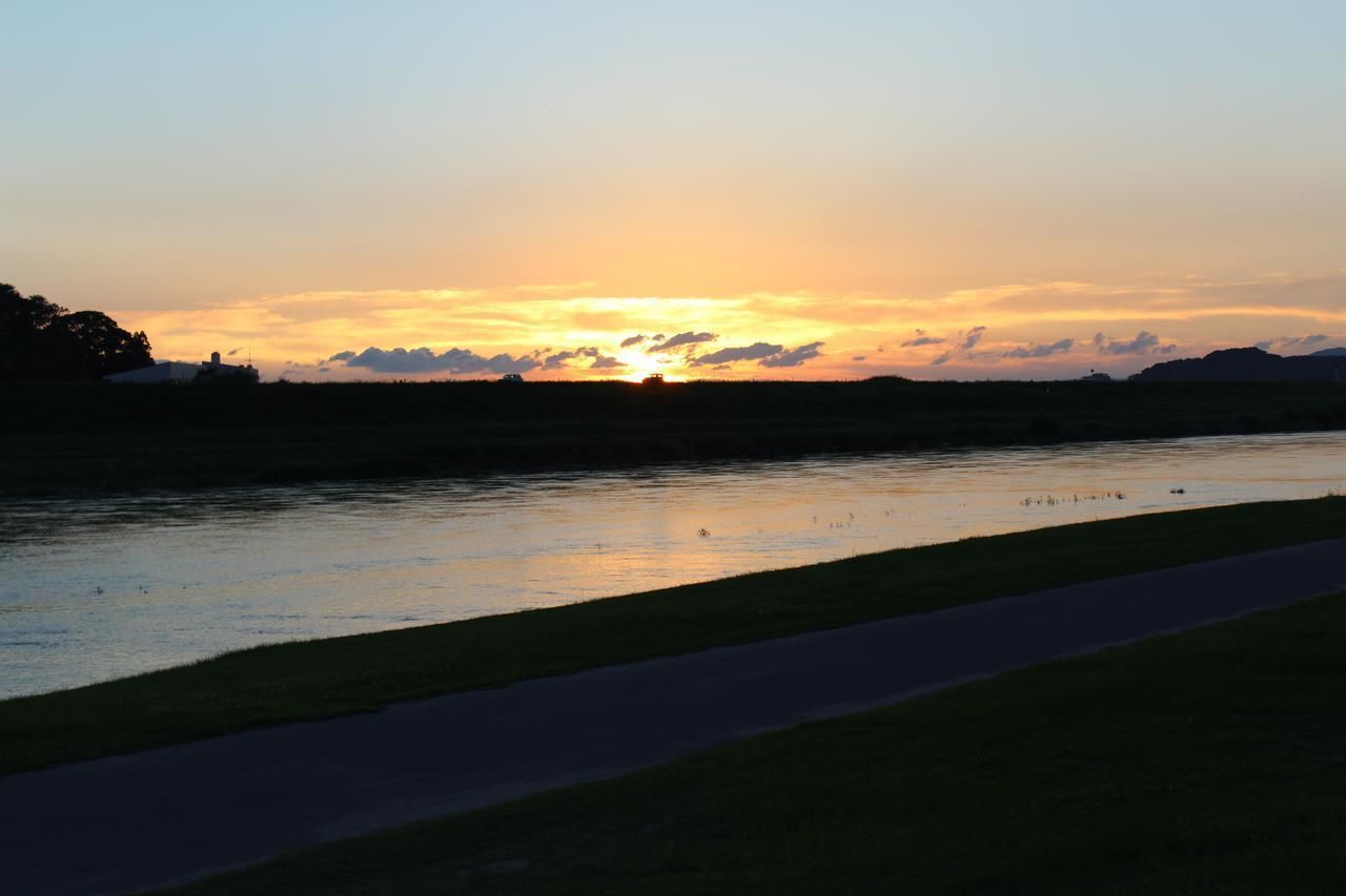 A sunset over a river with a path in the foreground.