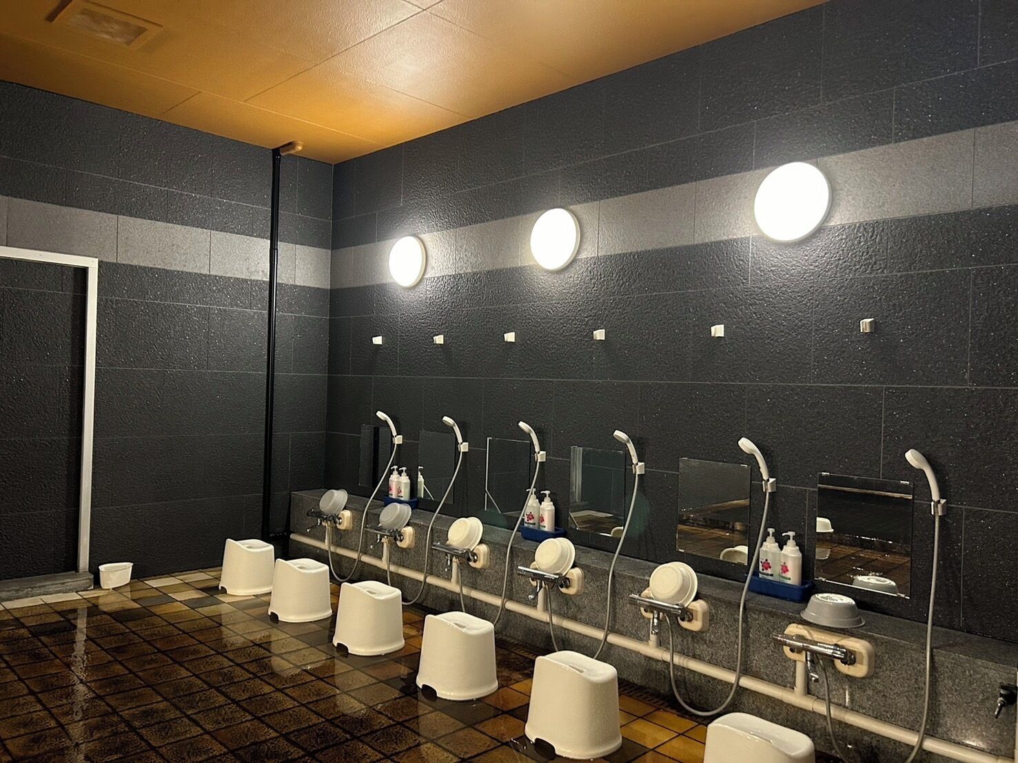 Eine öffentliche Toilette mit mehreren Waschbecken, Spiegeln und Papierhandspenderspenden.