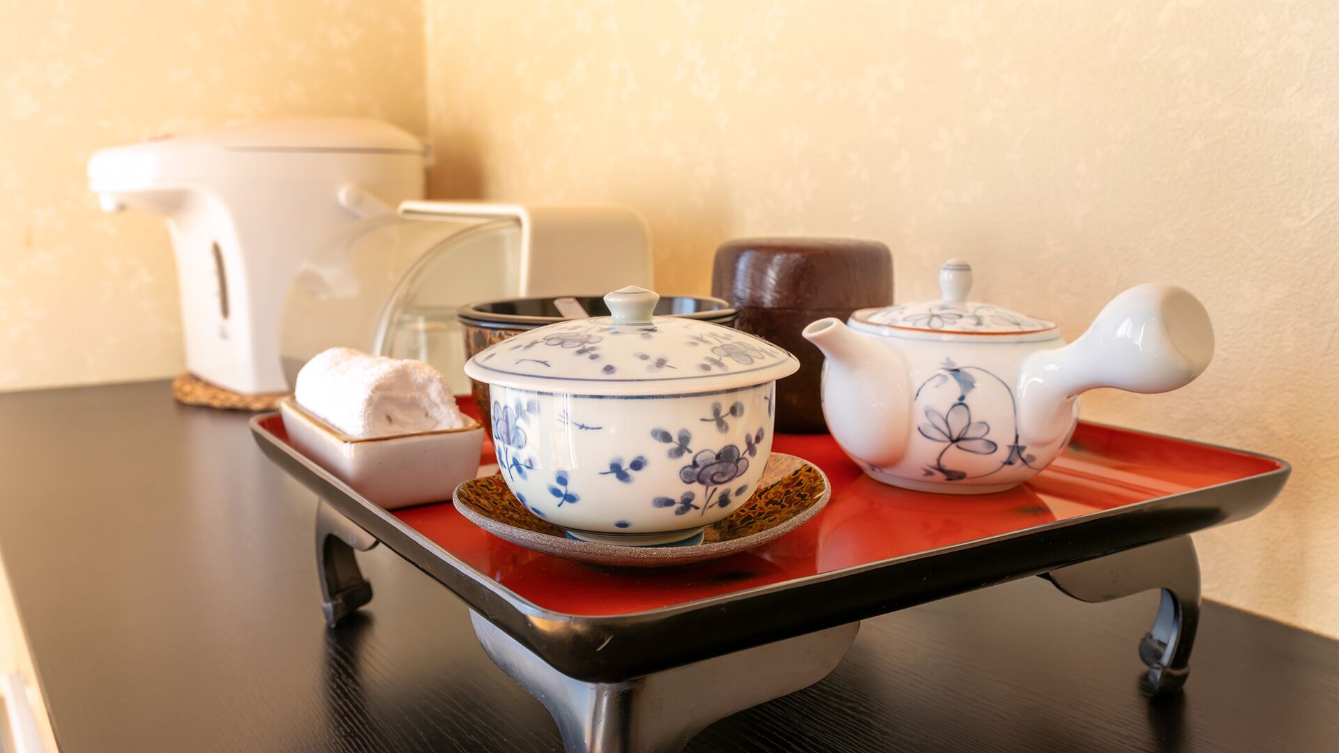 Un plateau avec une théière, une tasse à thé et un sucrier, posé sur une table.