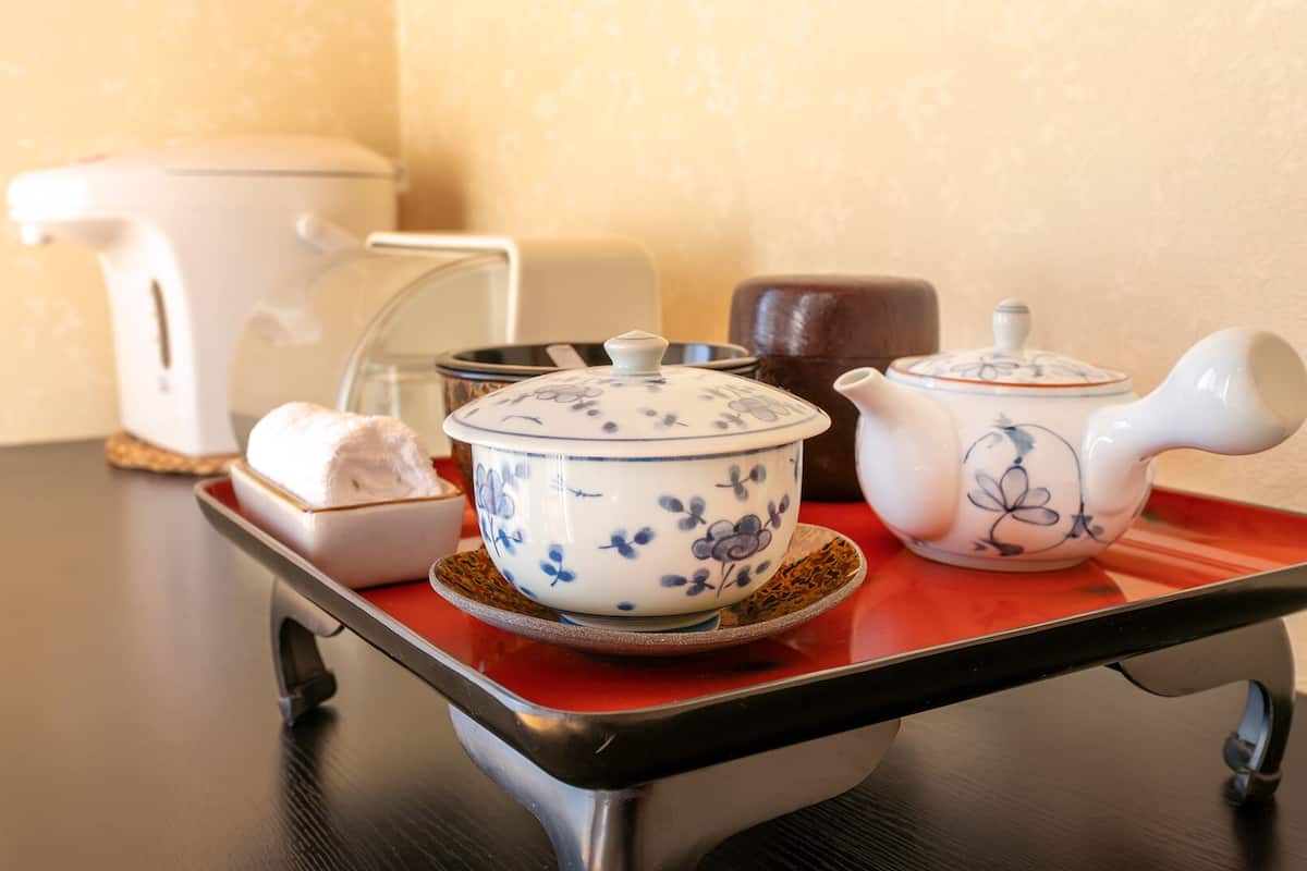 A tray with a teapot, a teacup, and a sugar bowl on a table.