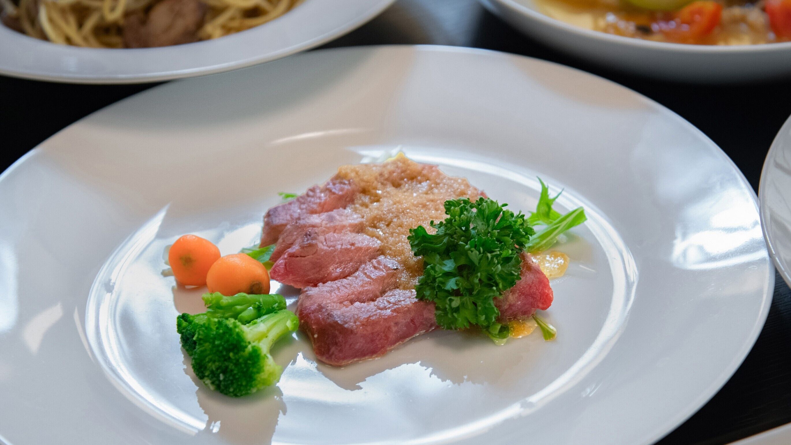 En tallerken mad med kød, broccoli og pynt.