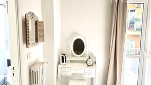 A white vanity with a mirror, a clock, and a radiator. - A Quattro Passi Da (Rome)