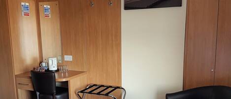 Une chambre d’hôtel comprenant un lit, un bureau, une chaise, une petite table et un canapé.
