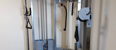 A gym with a bench press, weight stack, and various exercise machines.