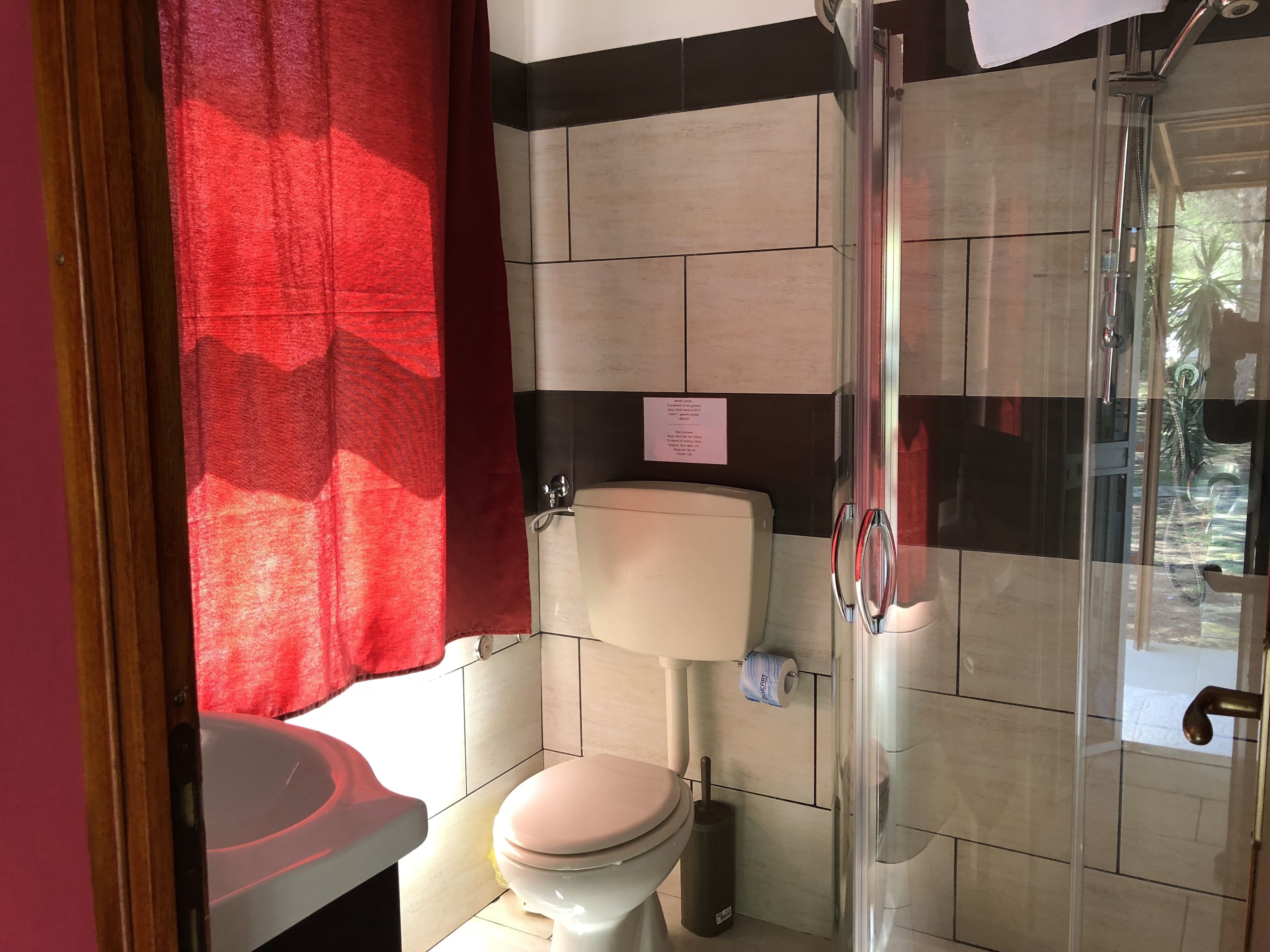 A bathroom with a toilet, a shower, and a sink.