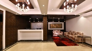 Eine moderne Lobby mit einer Rezeption, einer Couch und einem roten Teppich.
