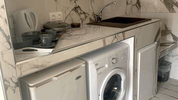 Standaard studio | Privékeuken | Een koelkast, een oven, een kookplaat, een waterkoker