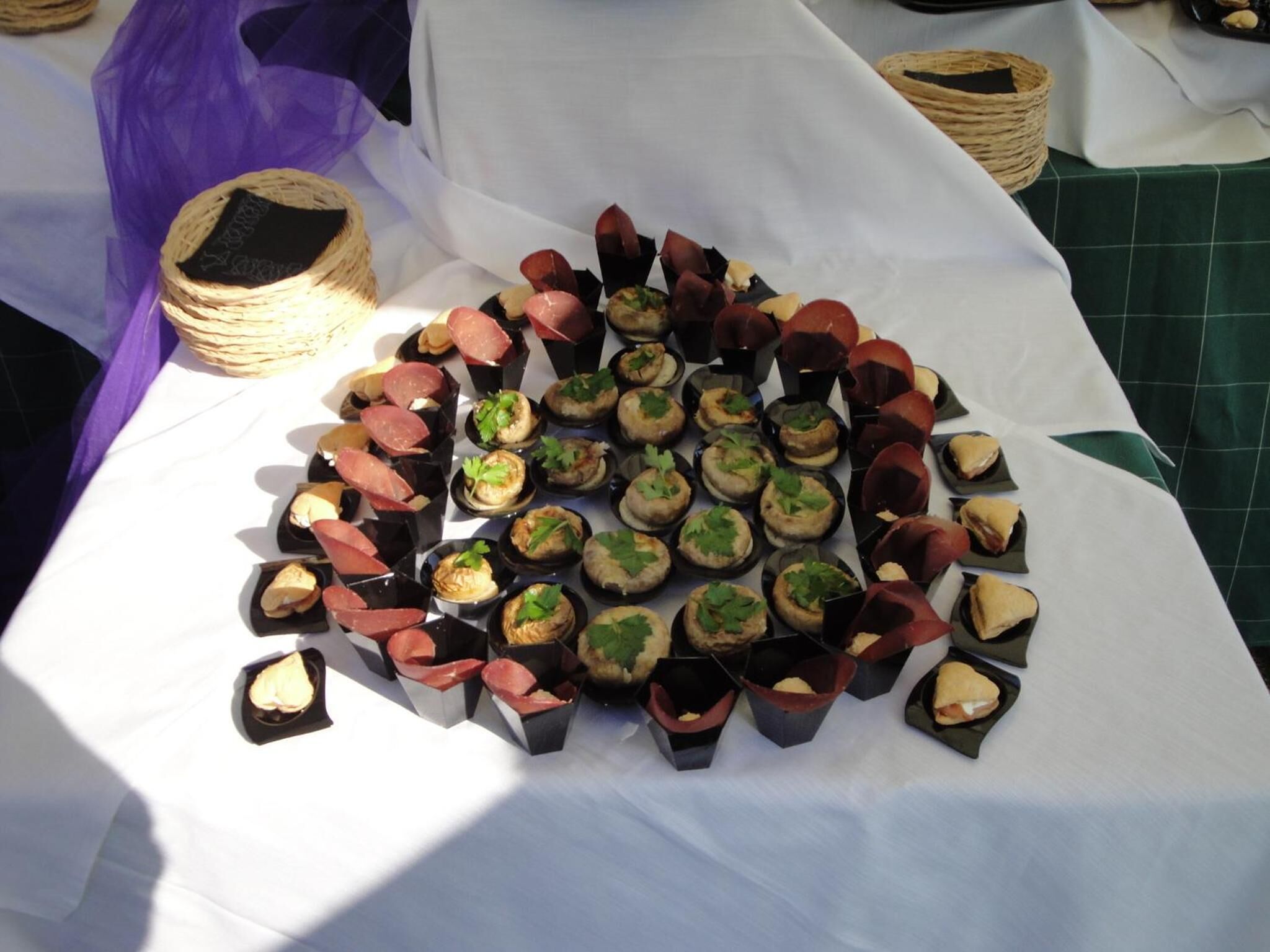 A table with various food items arranged in small black containers.