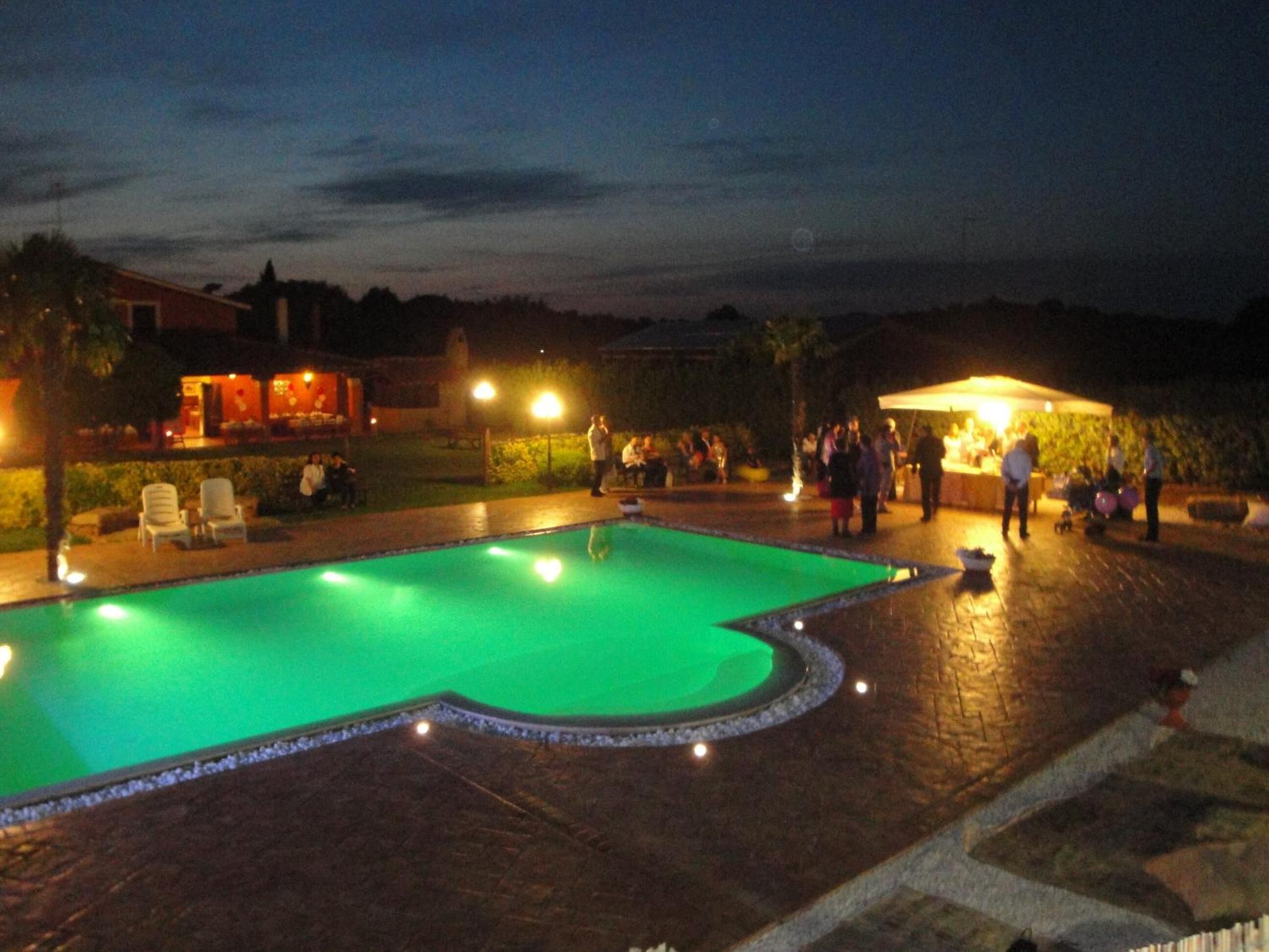 Una piscina al aire libre, sombrillas, sillones reclinables de piscina