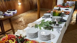 Ein Buffet mit verschiedenen Früchten und einem Koch, der im Hintergrund etwas zubereitet.