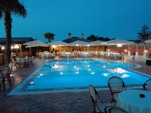 A poolside dining area with tables and chairs, surrounded by umbrellas and a pool. - Agriturismo la Valle di Ceri (Cerveteri)