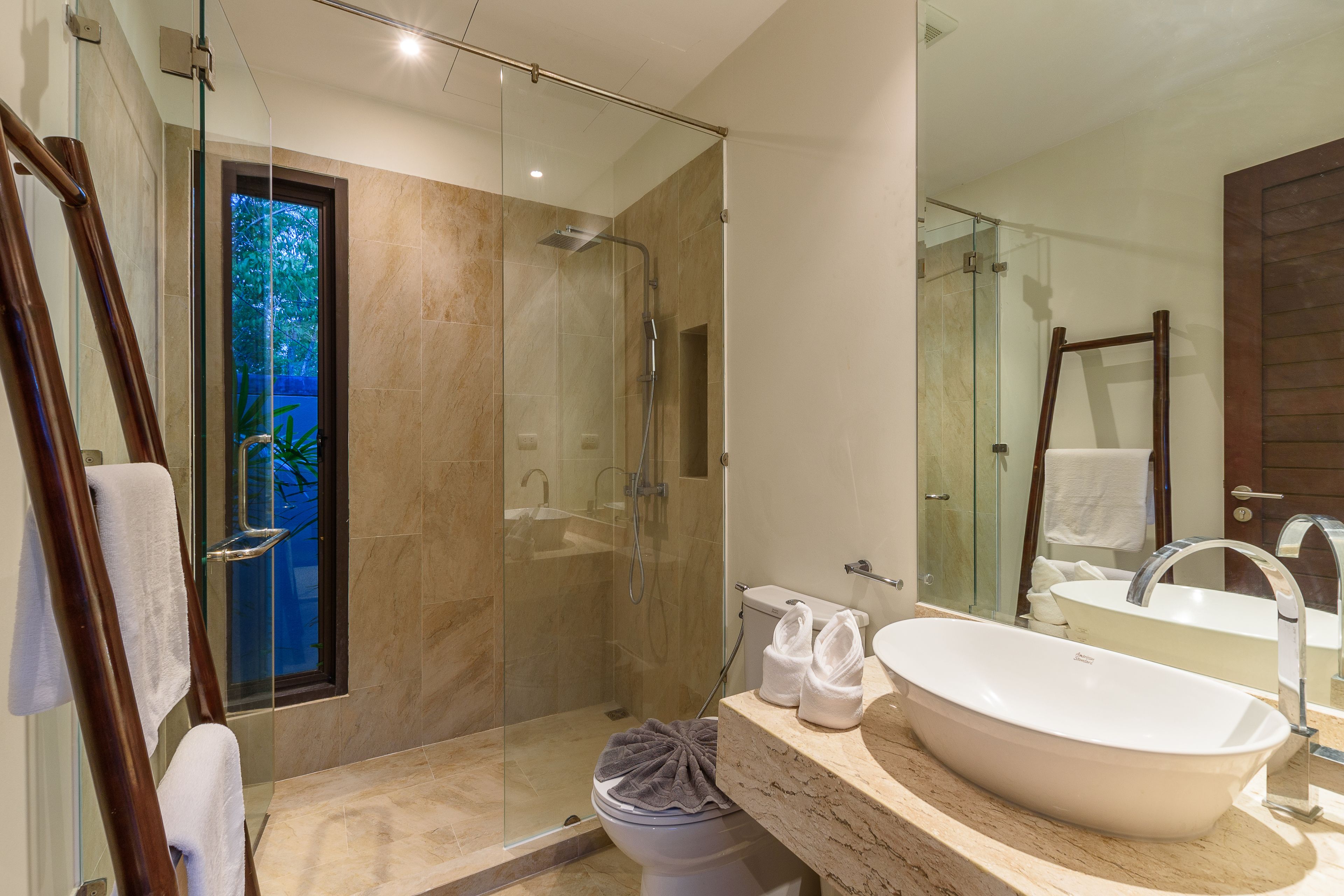 Un baño moderno con ducha de vidrio, una bañera independiente grande y un tocador con espejo.