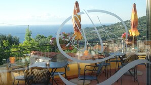 A terrace with outdoor seating, a view of the sea, and potted plants. - Hotel Liliana Diano Marina (Diano Marina)