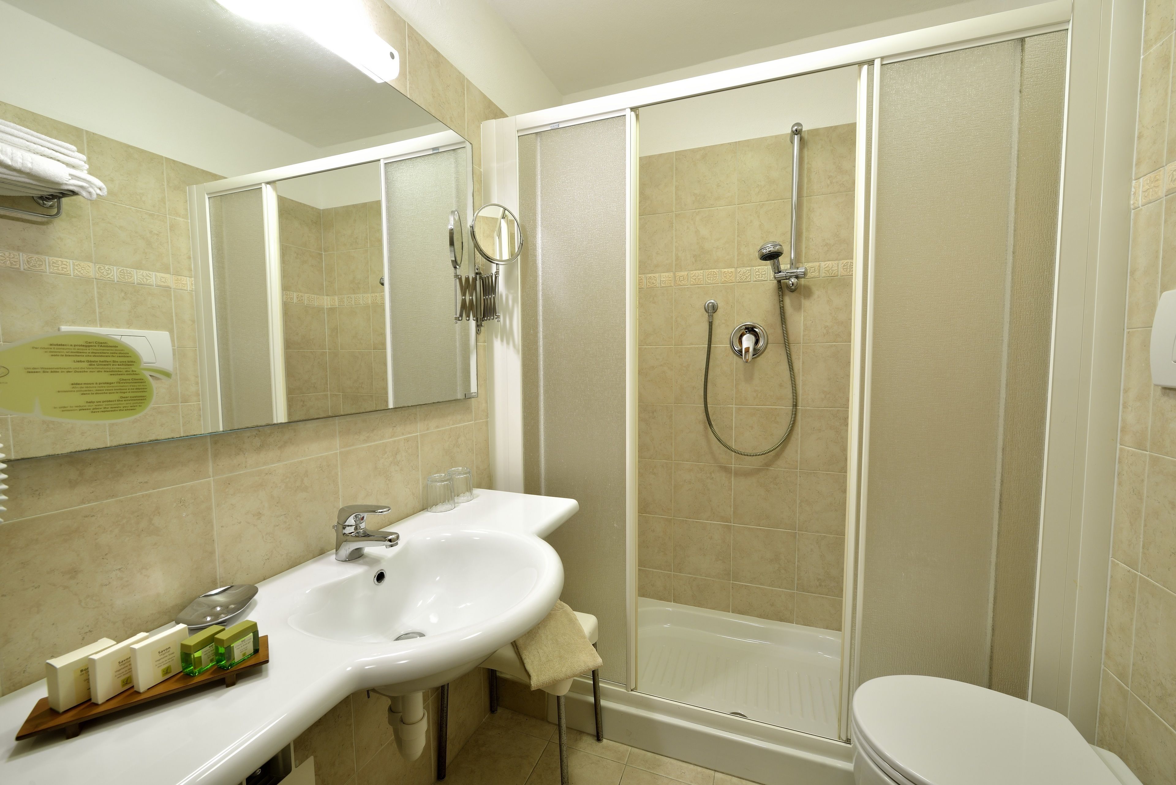 A bathroom with a sink, mirror, and shower.