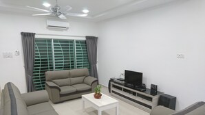 A living room with a sofa set, a coffee table, a TV stand with electronic devices, and a ceiling fan.