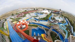 Parque acuático con toboganes variados y una gran fuente de agua circular.