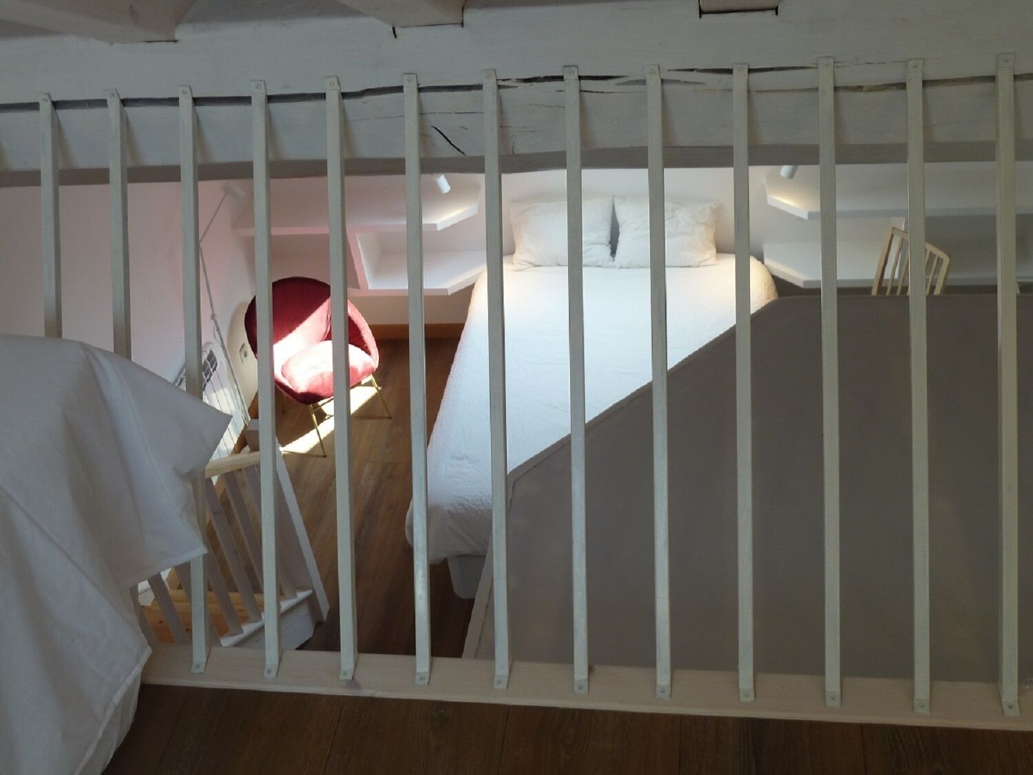A room with a bed, a chair, and a white partition.