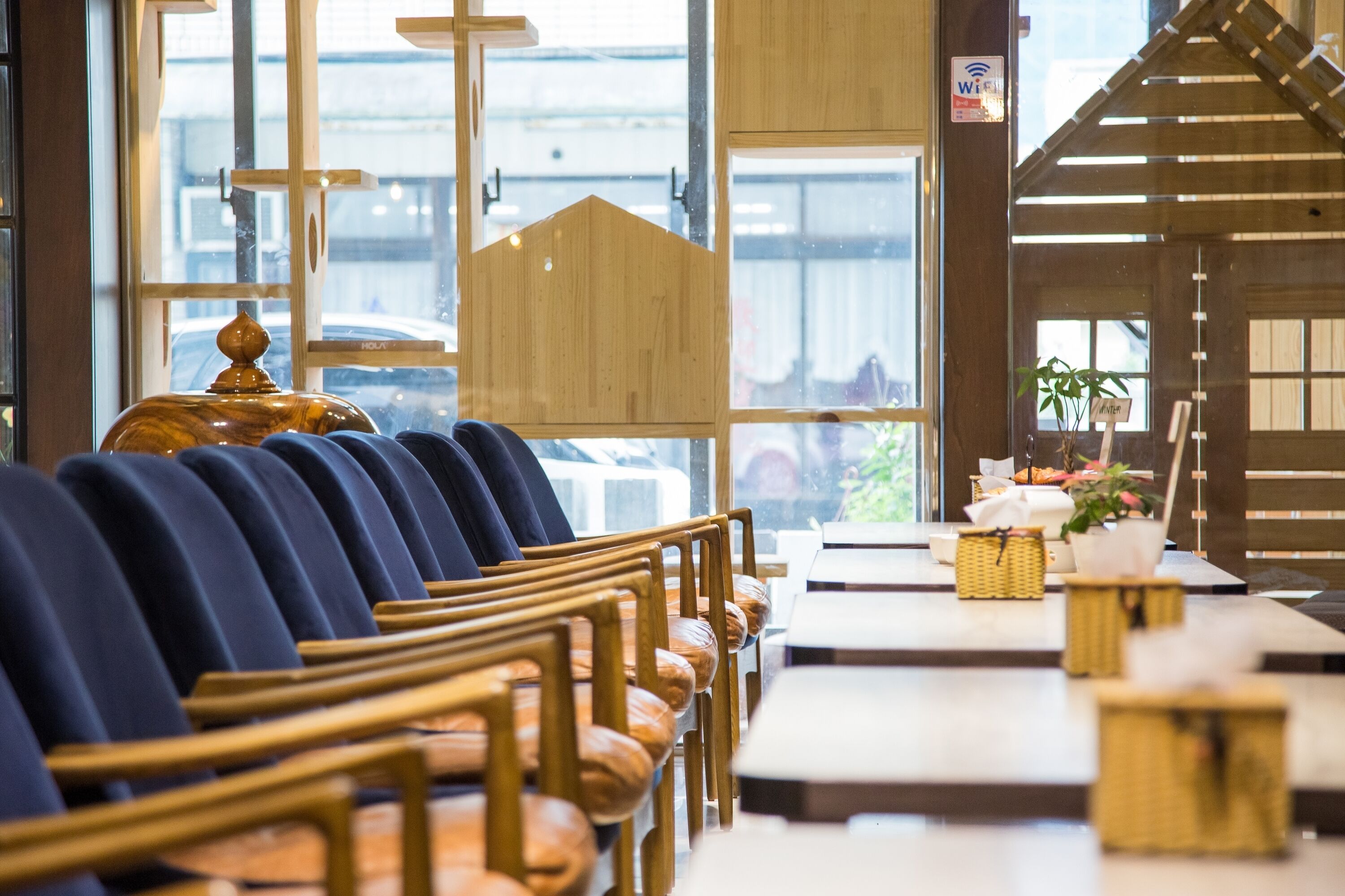 A church interior with pews, a wooden altar, and a view of the outside through large windows.