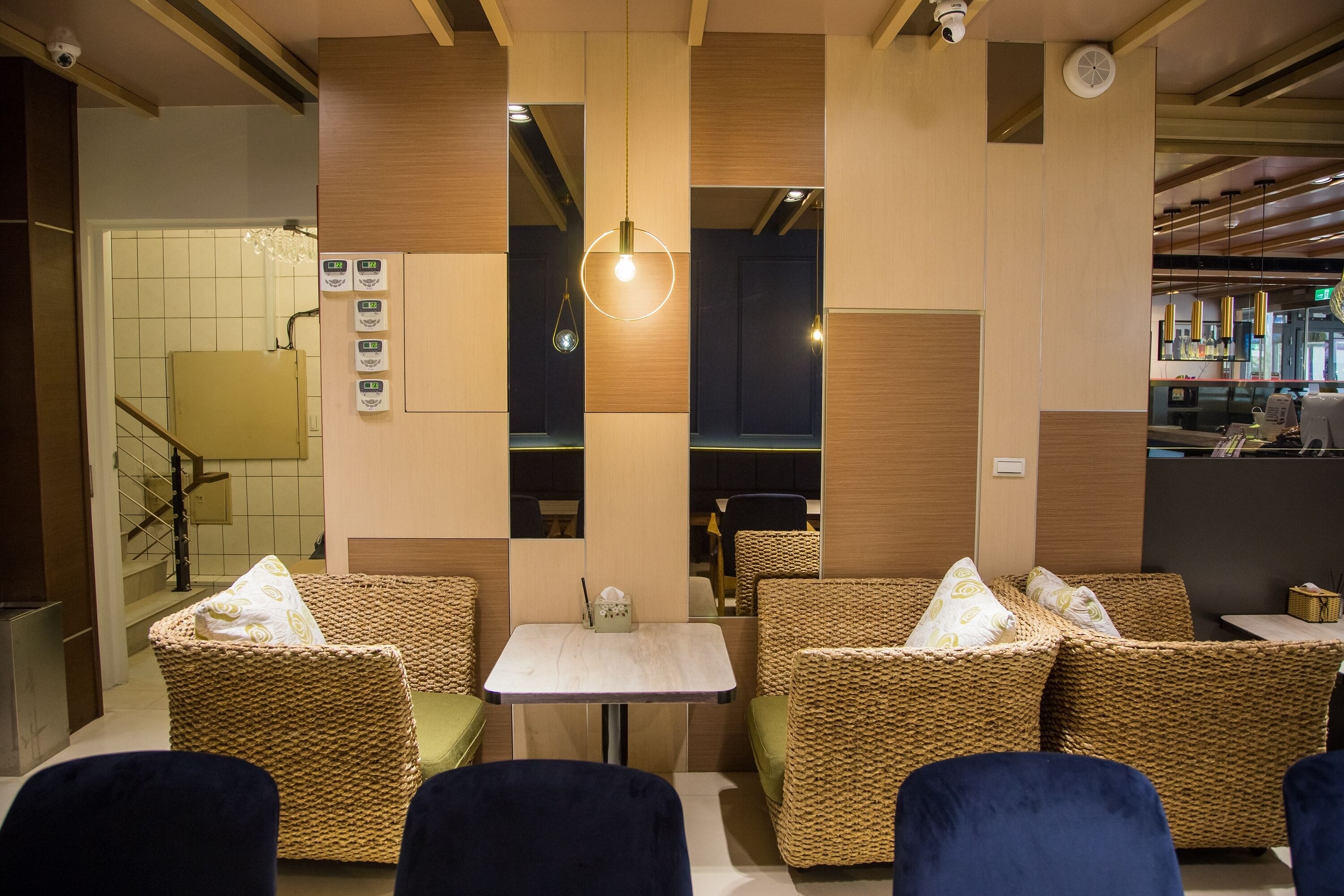 A modern interior with wicker furniture, a small table, and a hanging light fixture.
