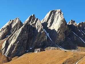 A mountain with sharp peaks and a small building at its base. - Zedlacherhof (Matrei in Osttirol)