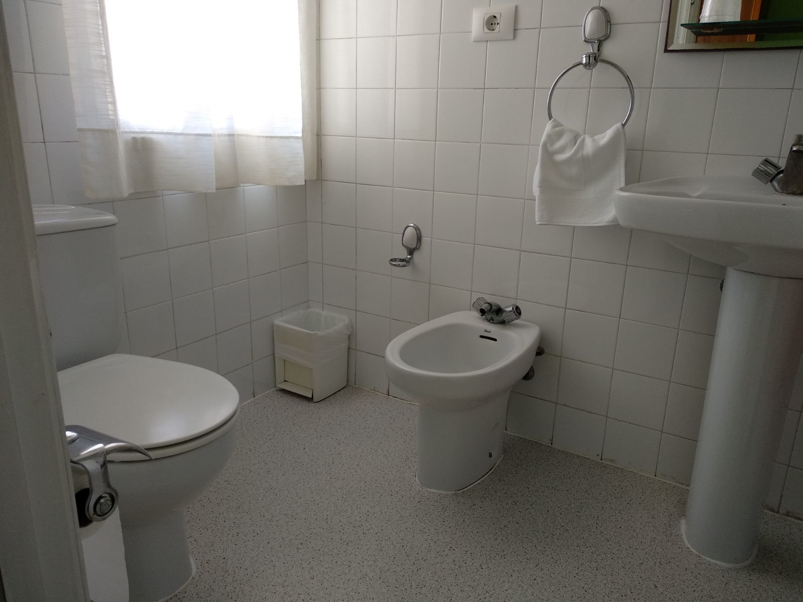 A bathroom with a toilet, bidet, and sink.