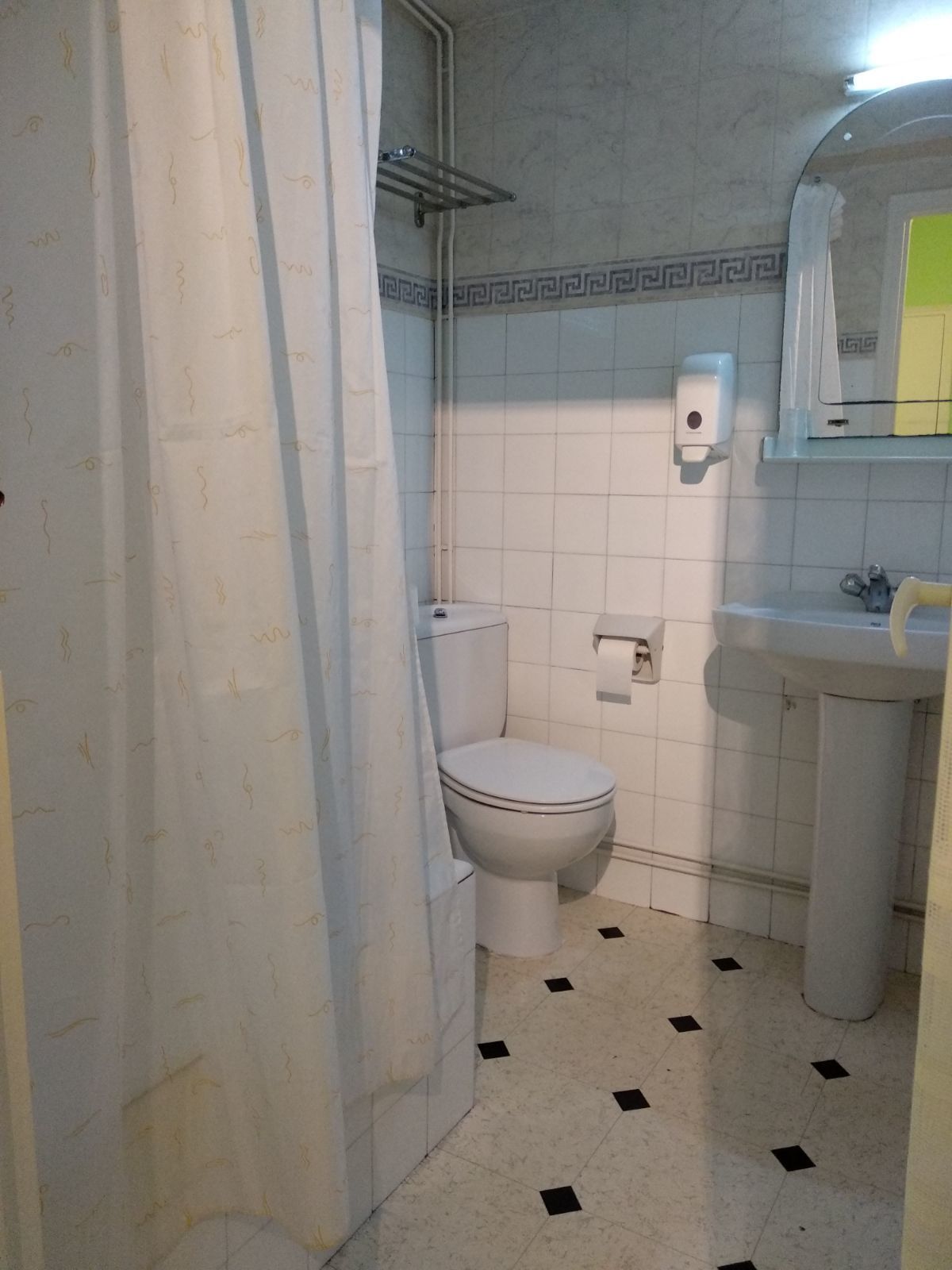 A bathroom with a toilet, sink, and shower area.