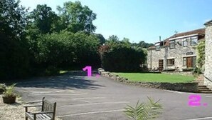 A stone building with a paved driveway and a bench. - The Old Malt House Hotel (Bath)
