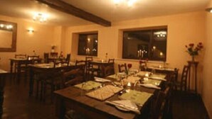 A dining area with tables set for multiple guests, wooden chairs, and a chandelier. - The Old Malt House Hotel (Bath)