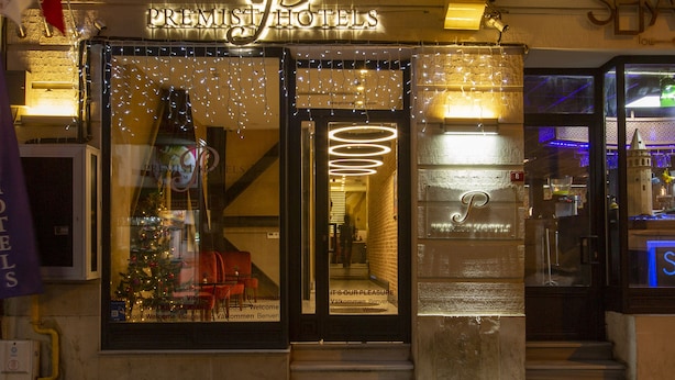 The exterior of a hotel with a neon sign, a Christmas tree, and a staircase leading to the entrance. - Premist Hotels Taksim - Special Class  (Istanbul)