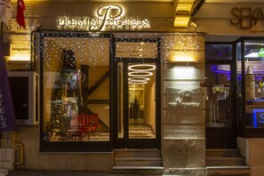 The exterior of a hotel with a neon sign, a Christmas tree, and a staircase leading to the entrance. - Premist Hotels Taksim - Special Class  (Istanbul)