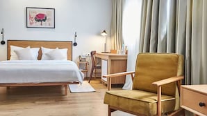 A hotel room with a bed, a desk, a chair, and a large window with curtains. - Urban Park Hotel (Tbilisi)