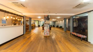 A spacious lobby with wooden flooring, a reception desk, and seating areas. - Urban Park Hotel (Tbilisi)