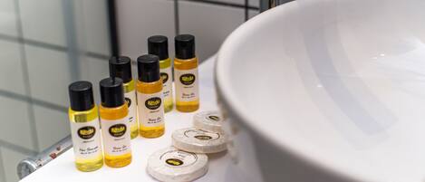 A bathroom sink with a white basin and several bottles of hand soap.