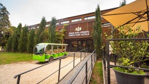 A green bus parked in front of a building labeled "URBAN PARK HOTELS". - Urban Park Hotel (Tbilisi)