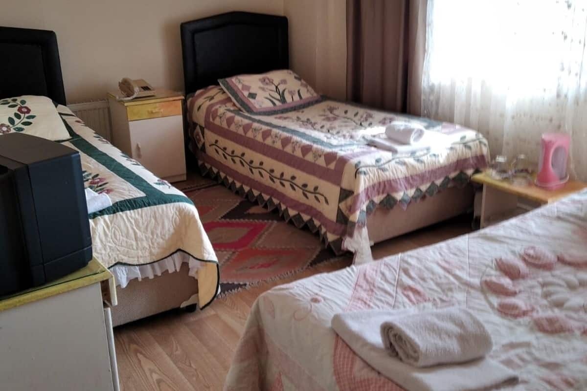 Un dormitorio con dos camas, un escritorio y una silla.