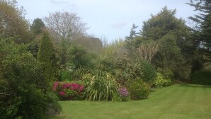 A well-maintained garden with various plants and a grassy lawn. - La Michele (St. Martins)