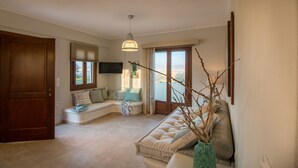 Un salon spacieux doté d’une grande fenêtre, d’une banquette intégrée, d’un canapé et d’un vase décoratif.