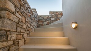 Un escalier avec des murs en pierre et un luminaire fixé au mur.