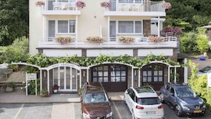 A two-story building with a balcony on each floor, a driveway with parked cars, and a sign reading "HAUS ERHOLDUNG". - Haus Erholung (Cochem)
